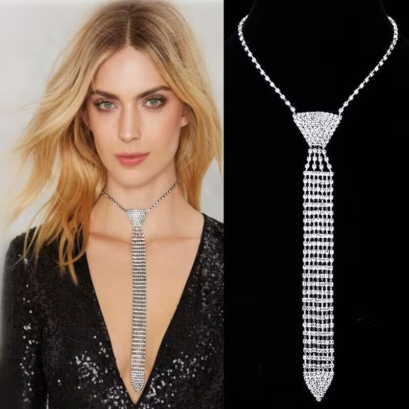 Blonde woman wearing a shimmering silver rhinestone necktie necklace with a black sequin plunging dress.