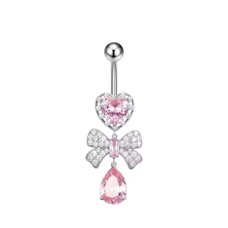 Romantic pink crystal heart and sparkling bow dangle belly ring on a white background.