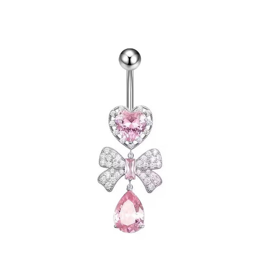 Romantic pink crystal heart and sparkling bow dangle belly ring on a white background.