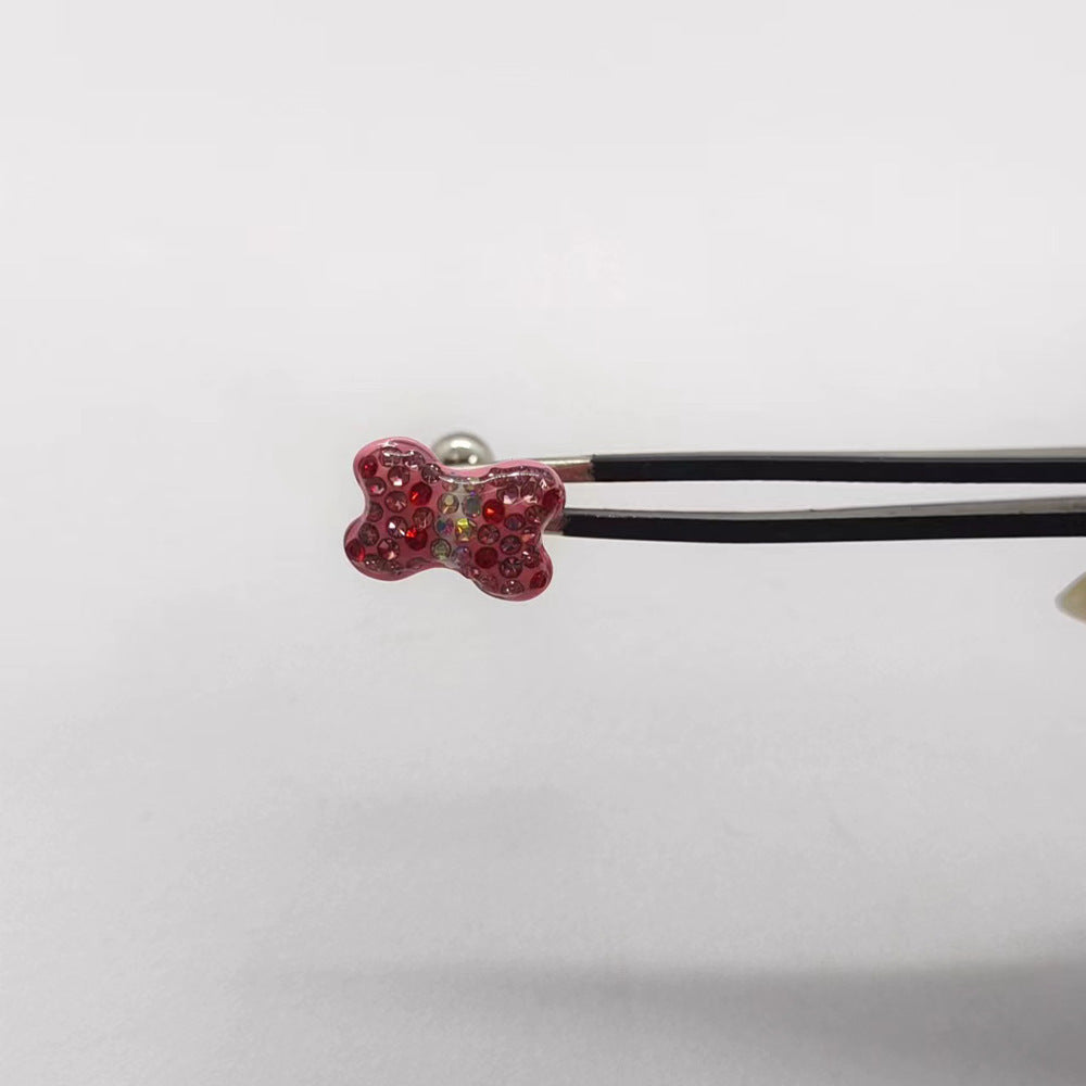 One Rose Red butterfly tongue barbell held with tweezers, showing its pink rhinestone top and metal ball end.