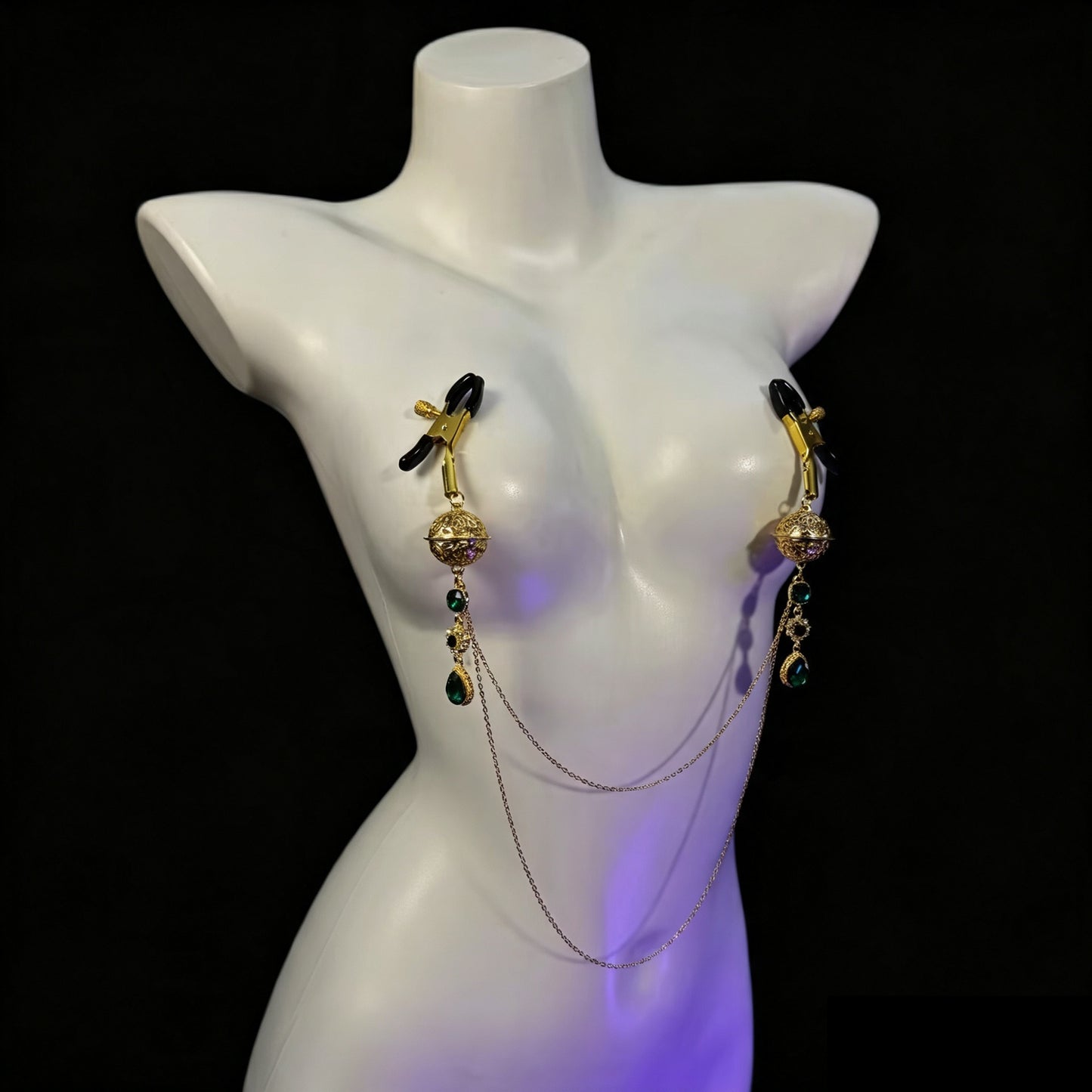 Non-pierced gold alligator nipple clamps with black rubber protective tips, vintage emerald pendants, and connected body chain.