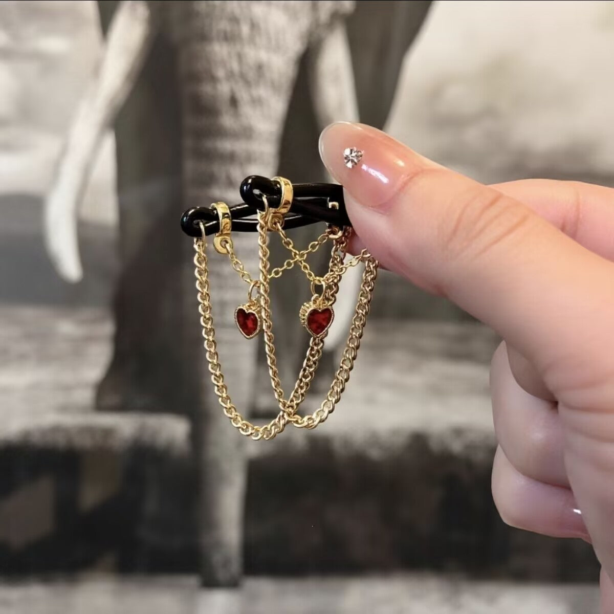 Fake non-pierced nipple jewelry with ruby red crystal heart pendants and dangling gold chains.