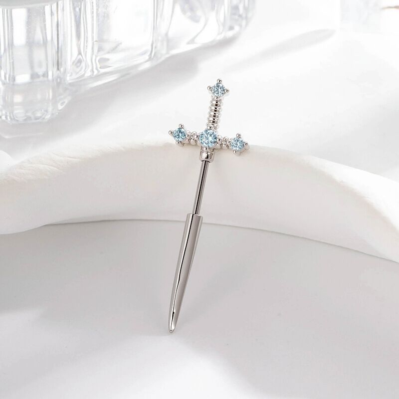 Silver dagger sword stud earring set with sparkling sky blue sapphire-colored zircon crystals.