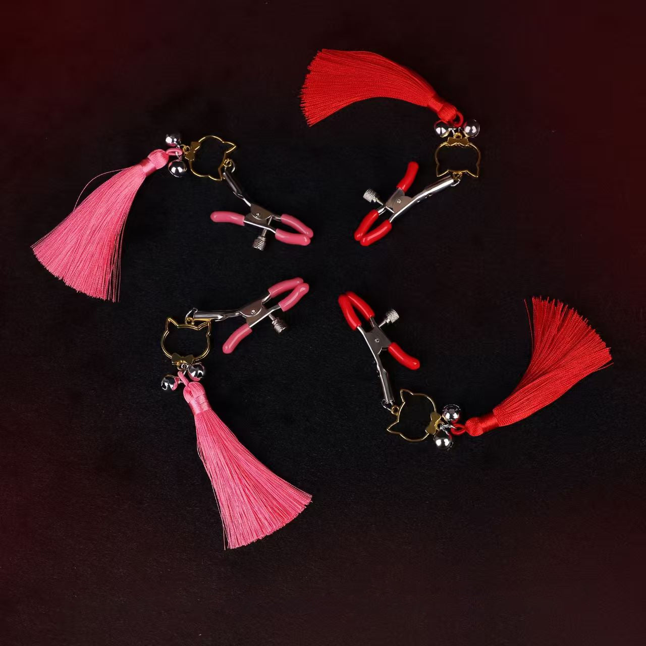 Overhead view of multiple pink and red decorative body clamps with playful tassels.