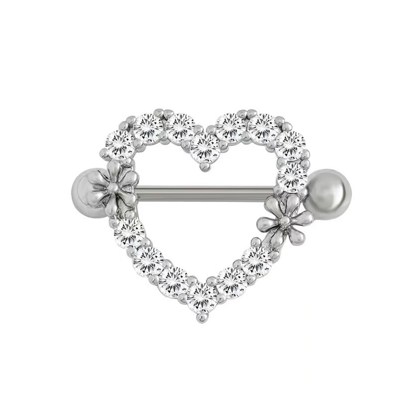 A close-up front view of a single silver heart-shaped nipple shield body piercing jewelry, decorated with sparkling round crystals and two small detailed flowers on a pure white background.