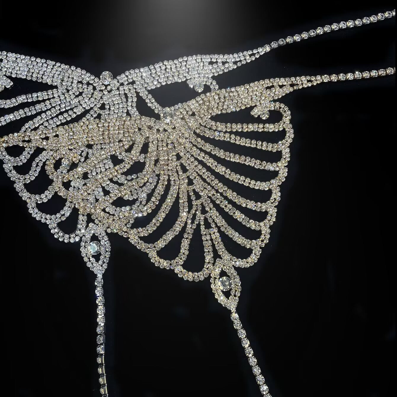 Detailed close-up of pave rhinestone butterfly wing centerpiece showing brilliant crystal craft.