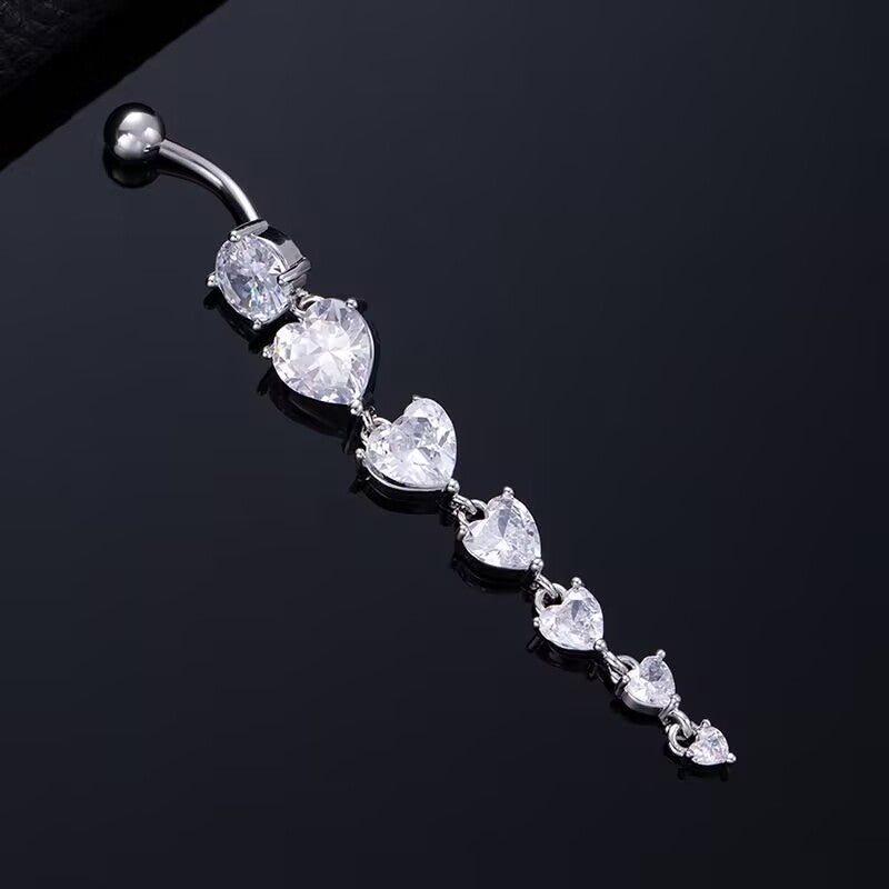 Silver dangle belly button ring featuring graduated heart cubic zirconia crystals on a black reflective background.