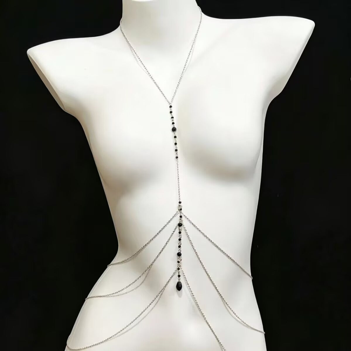 Front view of a silver multi-layer body chain harness with black beads on a white mannequin.