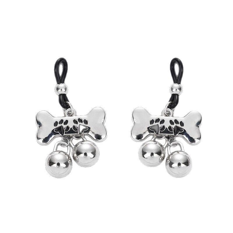 Symmetrical view of two silver bone and bell nipple jewelry pieces on a plain white background.