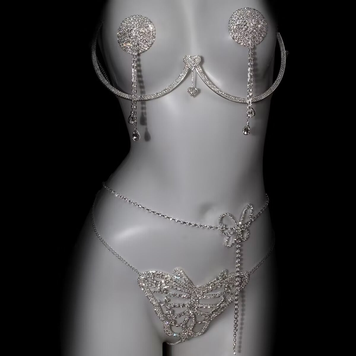 Silver crystal body chain harness set featuring underwire top, tassel nipple covers, and butterfly panty chain on mannequin.