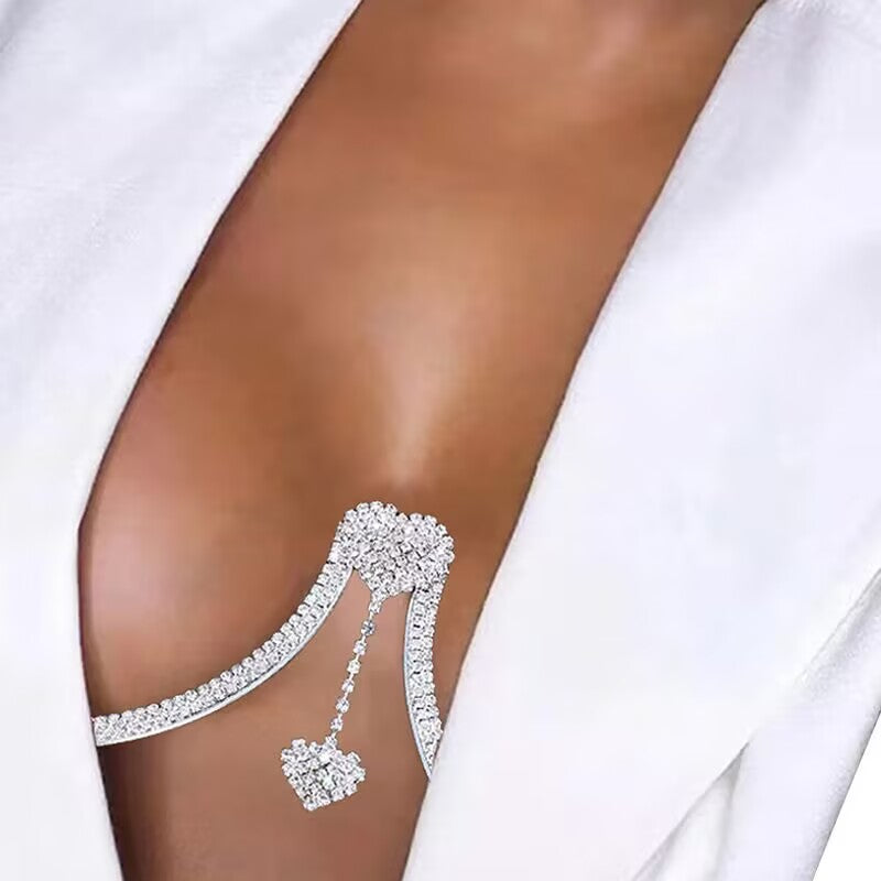 Model wearing silver rhinestone heart breast bracket chain under an open white blazer coat.