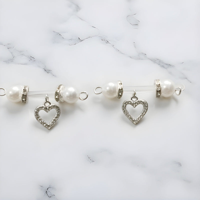 Matching pair of silver-tone non-piercing nipple jewelry with white pearl-look ends and sparkling open-heart charms