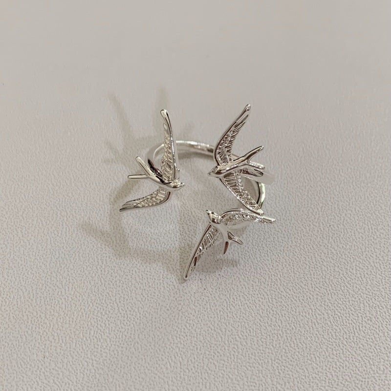 One silver-tone three-swallow ring showing textured wings and the curved ring band.