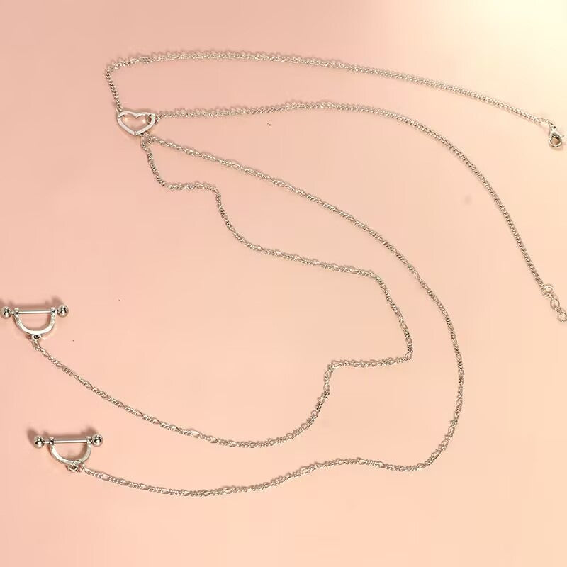 Side angle view of the single cutout heart connector body chain necklace with non-adjustable U-shaped nipple rings, displaying the delicate chain link pattern.