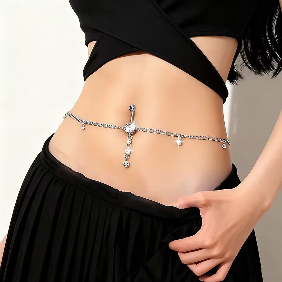 Close-up of dangling belly button ring waist chain accentuating slim waist line.