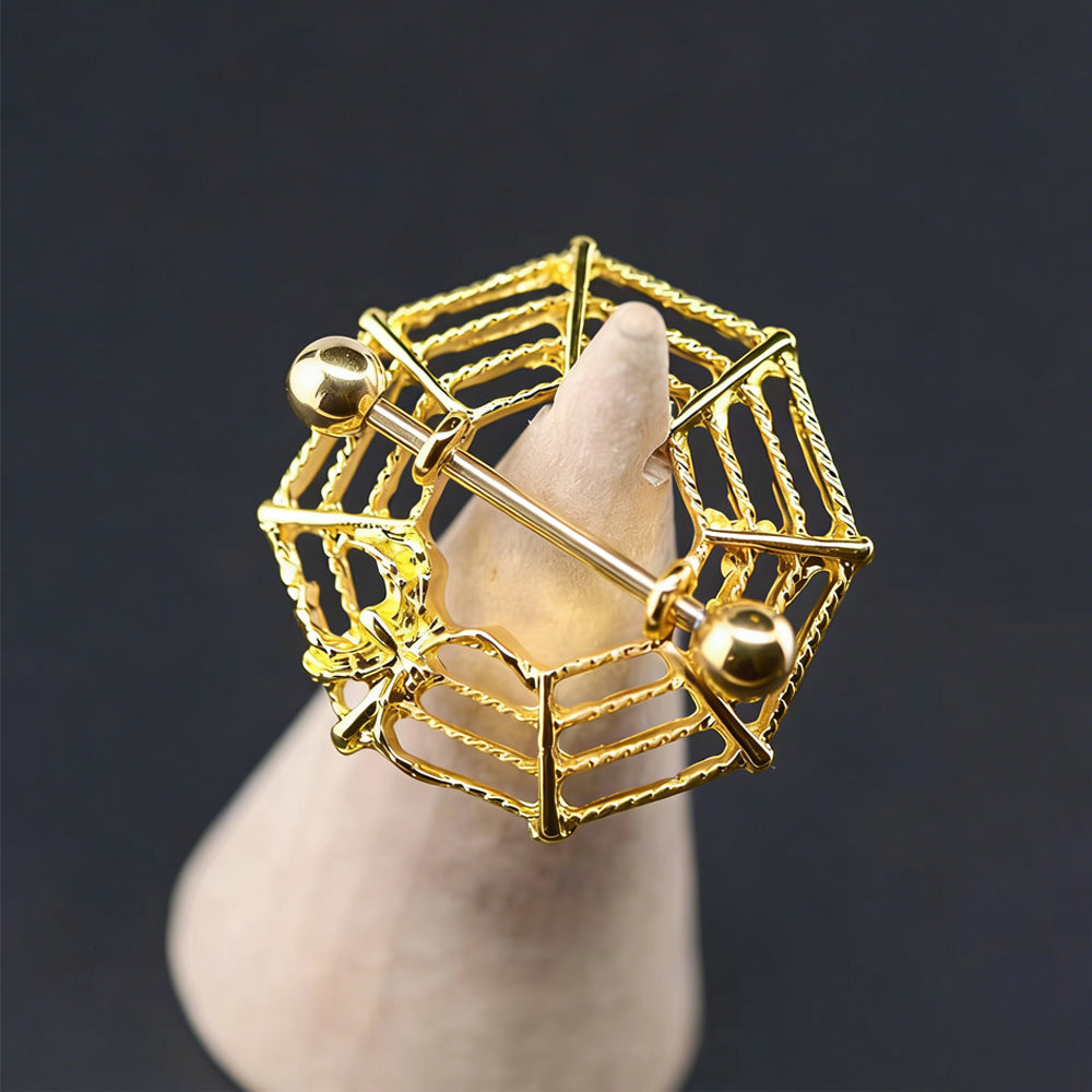 Aesthetic display of a gold spider web nipple shield on a cone stand with dark background.