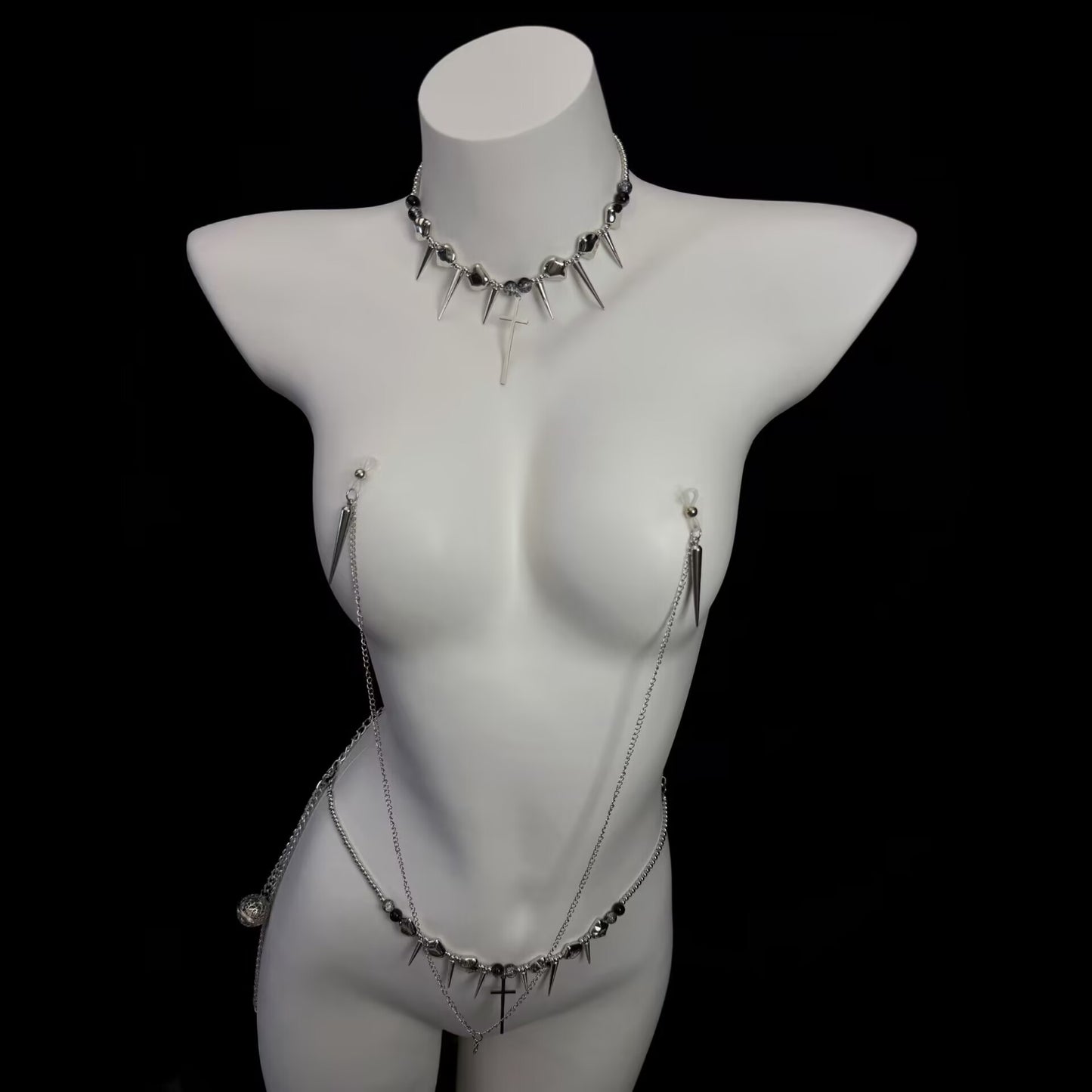Gothic punk body jewelry setup featuring connected cross nipple harness and spike cross waist belt.