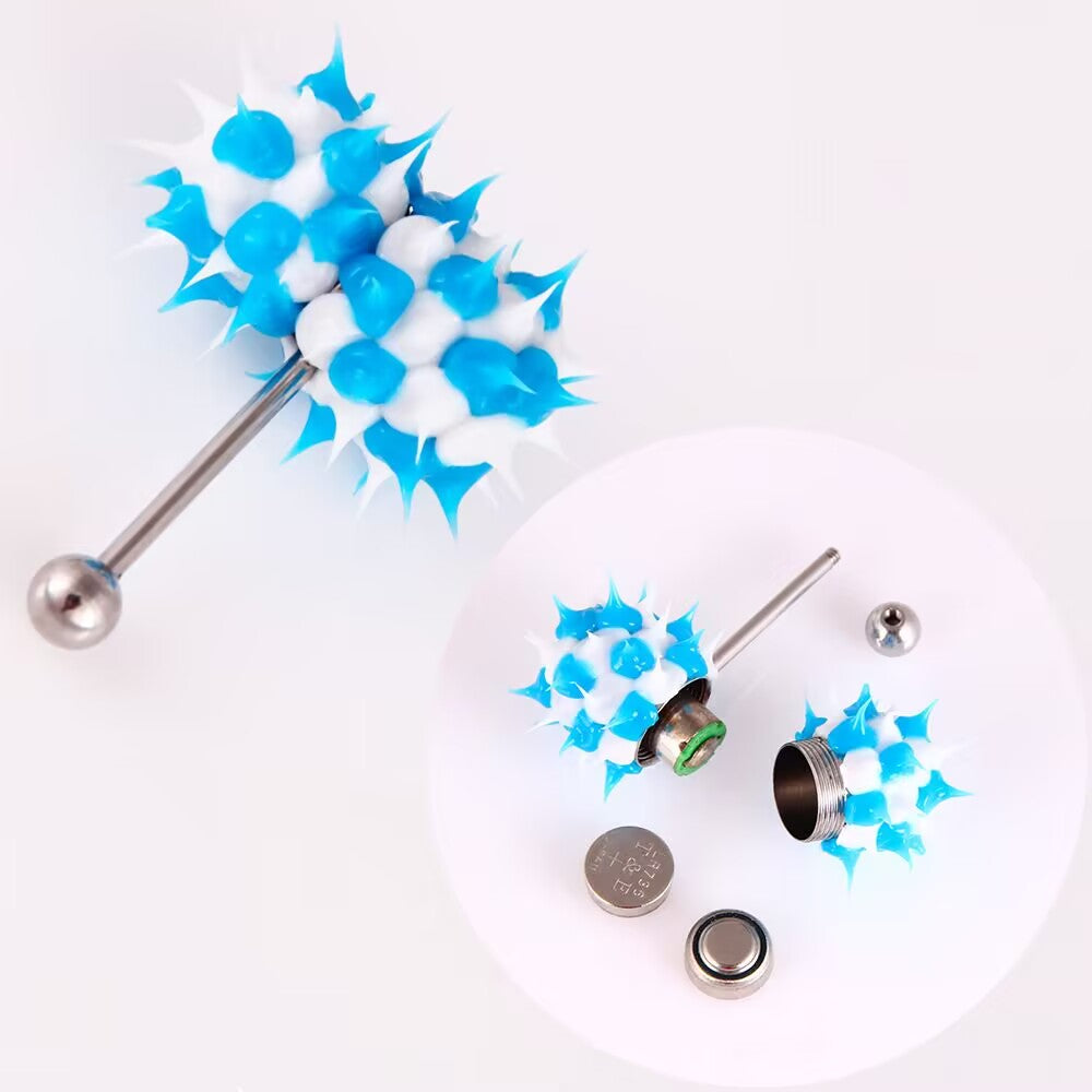 Blue and white spiked vibrating tongue barbell disassembled showing internal battery component and micro button batteries.