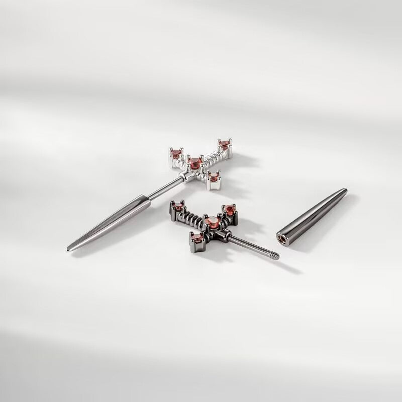 Close-up of the threaded screw-back mechanism showing the detachable sword-tip closure on the dagger earring.