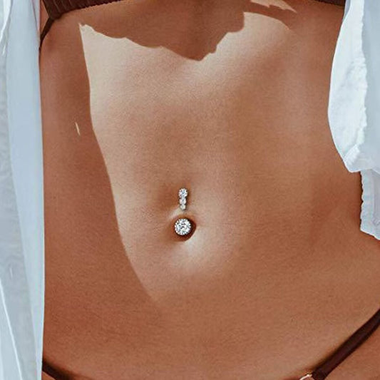 Sparkly triple CZ curved top belly button ring worn on model navel piercing