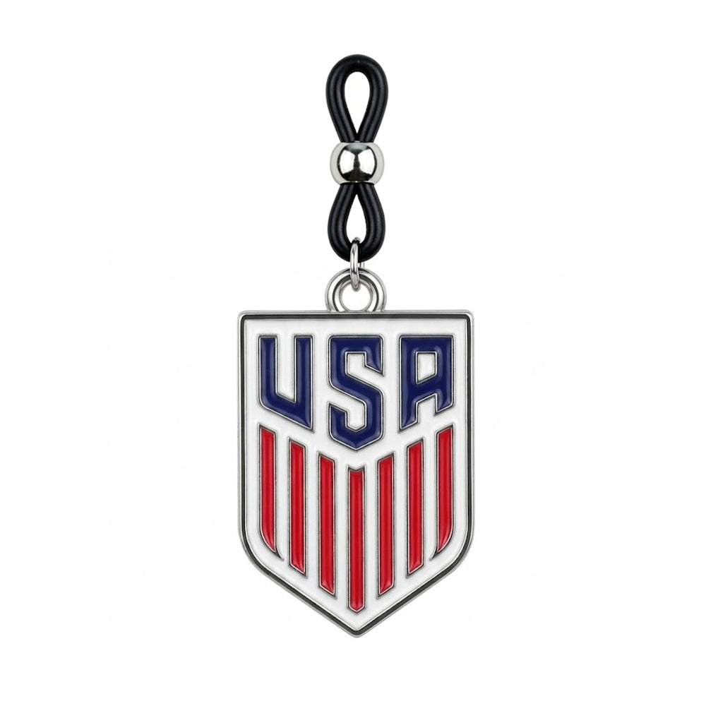 A single non-piercing USA shield nipple ring featuring an adjustable black rubber loop with a silver sliding bead and a hanging red white and blue USA patriotic crest charm on a pure white background.