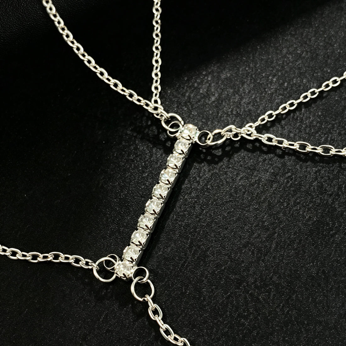 Macro shot of a vertical row of precision-set crystal rhinestones connecting the interconnected chest chains.
