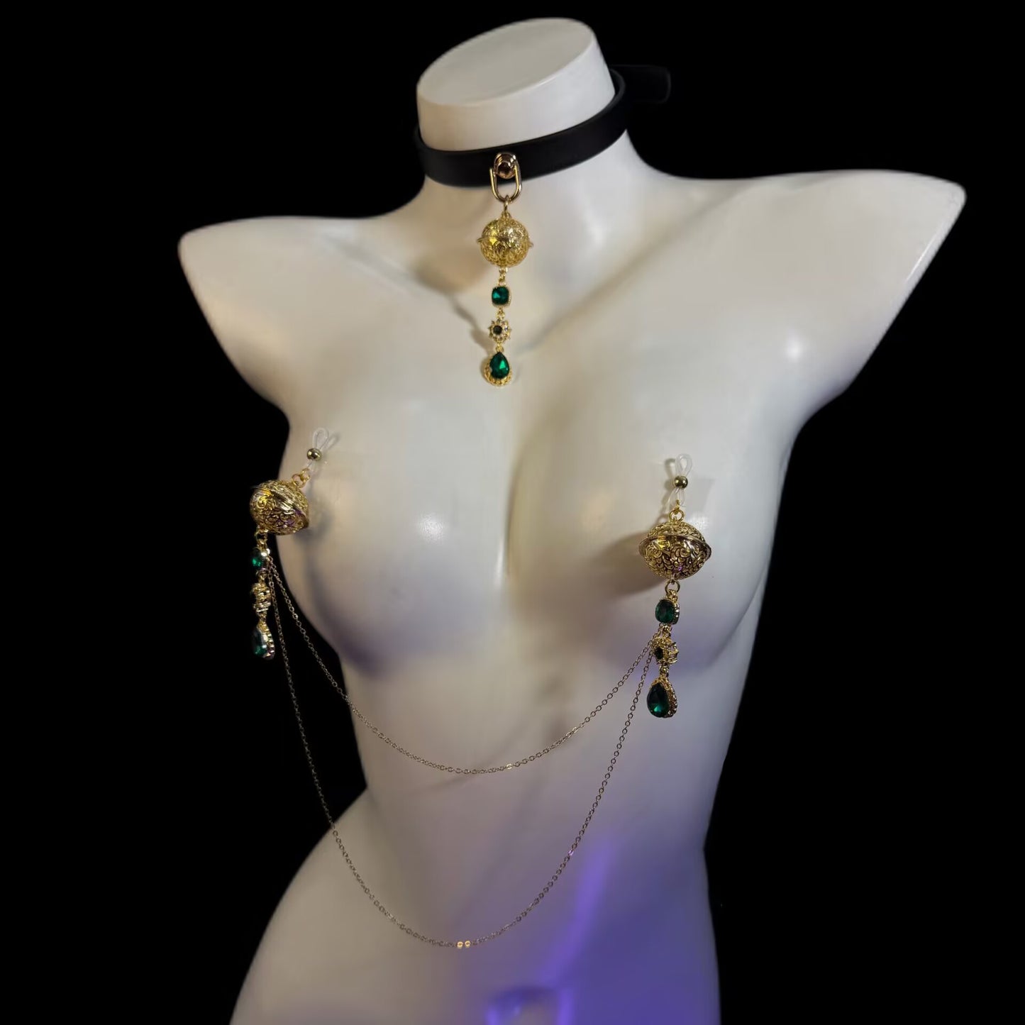 Non-pierced emerald nipple jewelry set with clear silicone loops, dual gold body chain, and black leather collar choker on display mannequin.