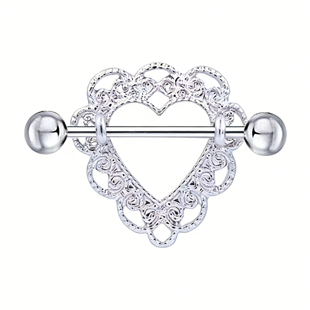 Close-up of a silver heart-shaped nipple shield with intricate lace filigree patterns and a straight barbell.