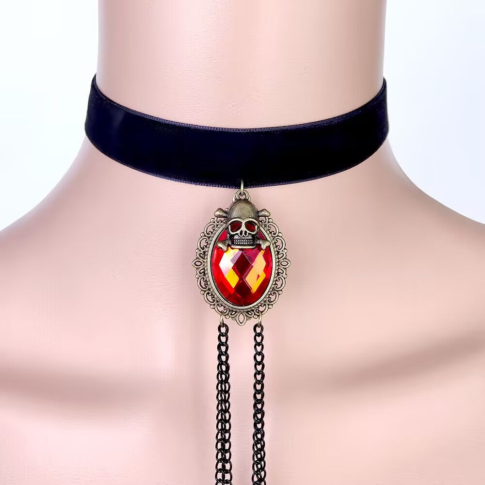 Close-up of black velvet choker necklace featuring vintage skull framed red oval gem pendant