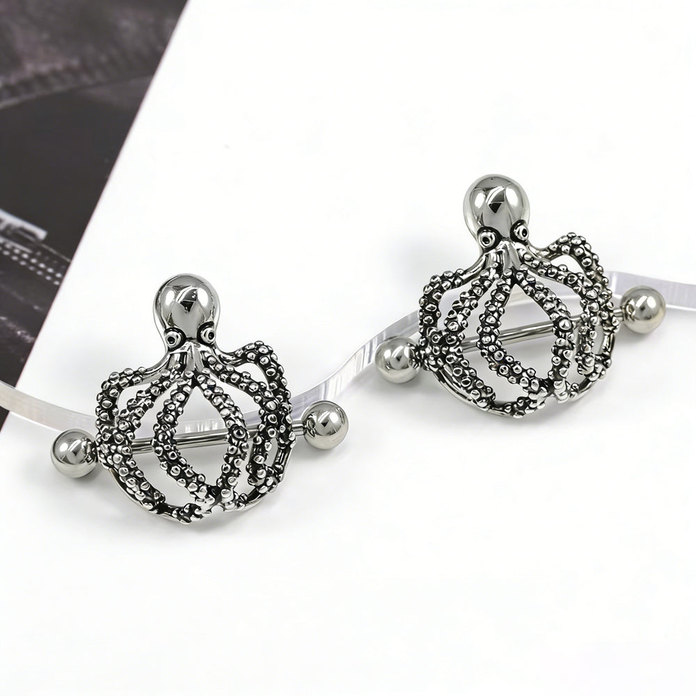 Vintage silver-toned octopus nipple jewelry displayed on a creative surface for fashion styling.