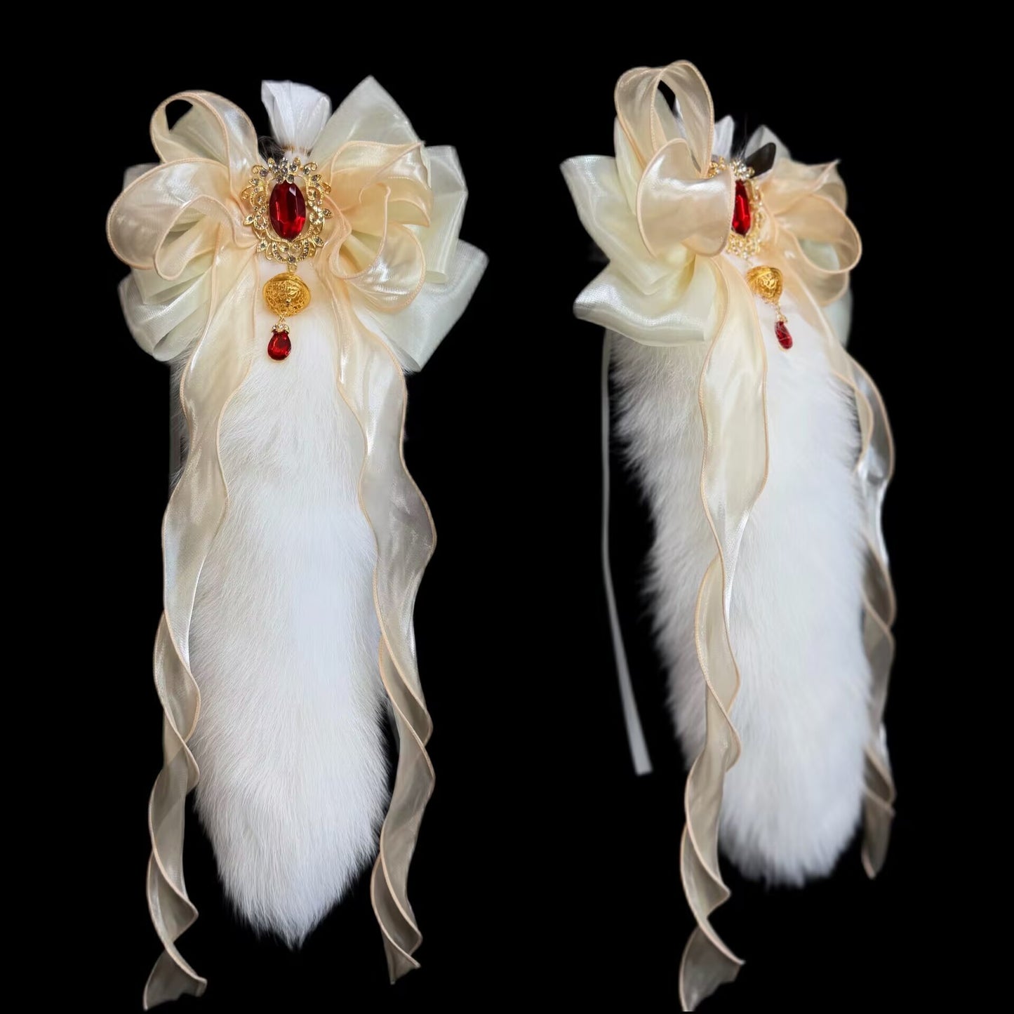 White plush faux-fur tail accessory decorated with a champagne ribbon bow, vintage gold jewel, and hanging crimson gem drop.