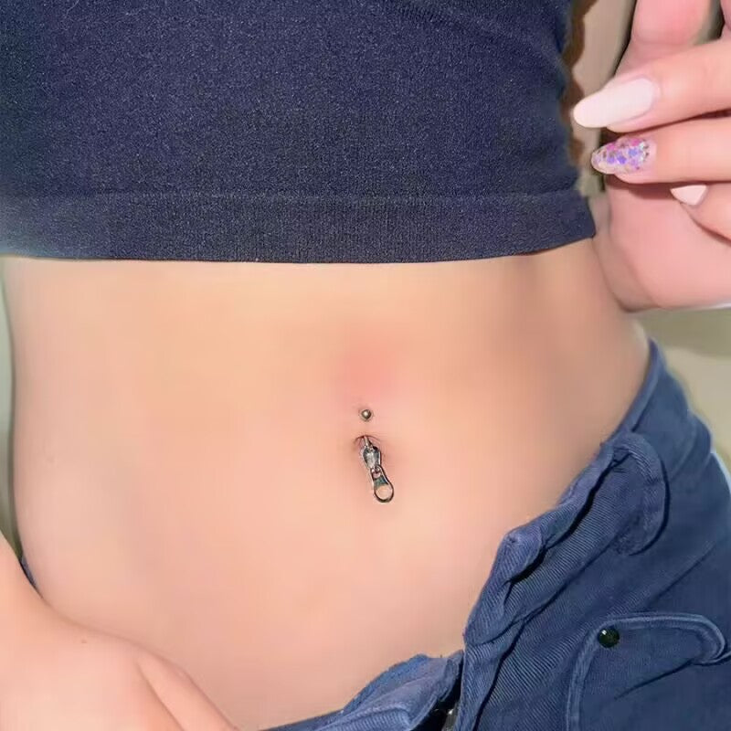 Edgy Y2K aesthetic zipper belly button ring styled with low-rise jeans and short crop top.