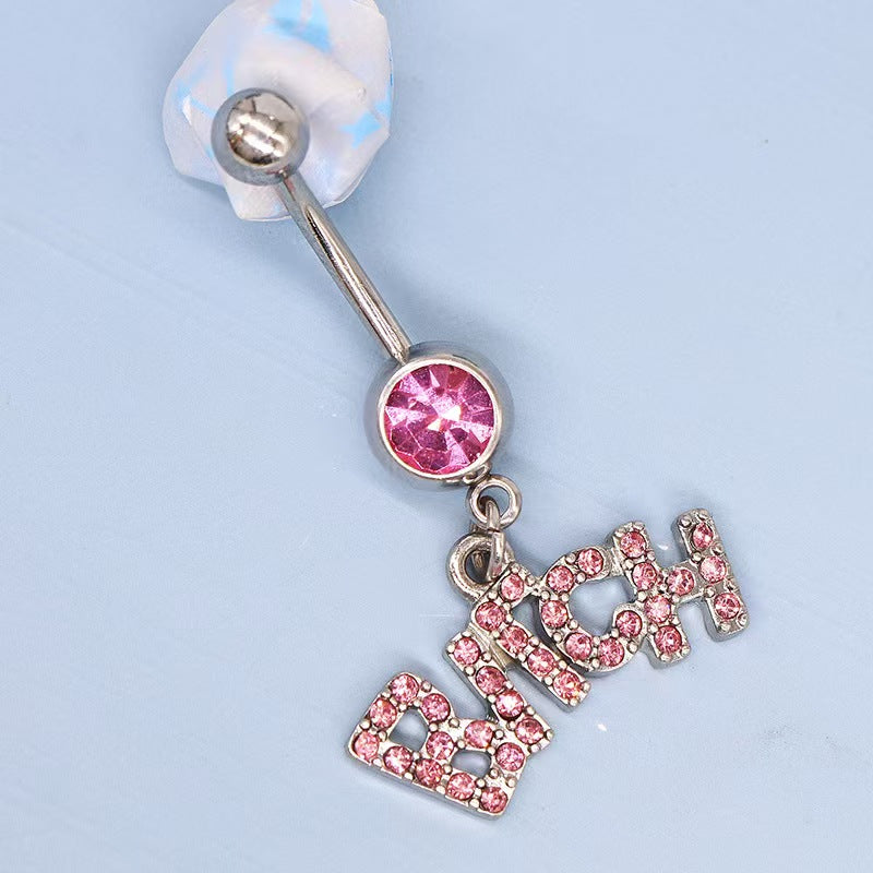 Close up lifestyle view of a silver Y2K belly button ring with a pink crystal and a Bitch dangle charm lying on a soft blue background.