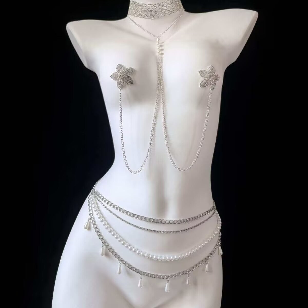 Silver Y2K star non piercing nipple chain connected to a multi layer pearl belly chain with teardrop pearls on a white mannequin torso, showing full body jewelry set styling.